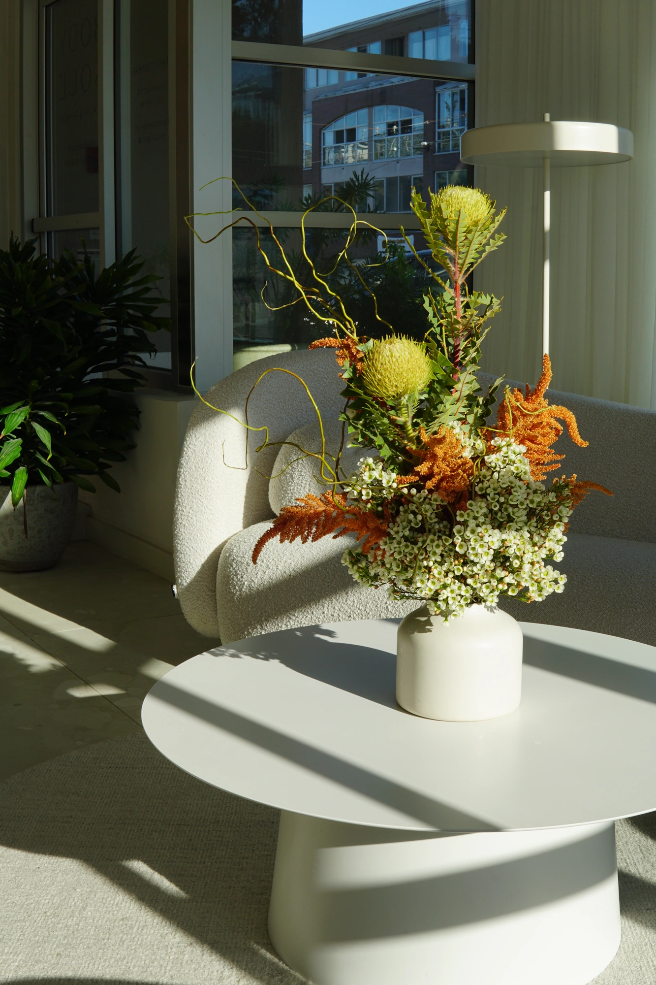 Banksia and orange foliage arrangement in afternoon light