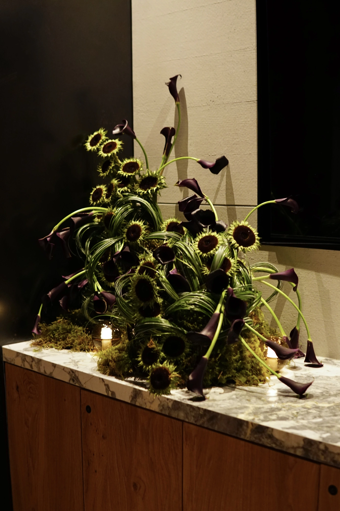 Dark calla lily and sunflower wedding installation by flöde