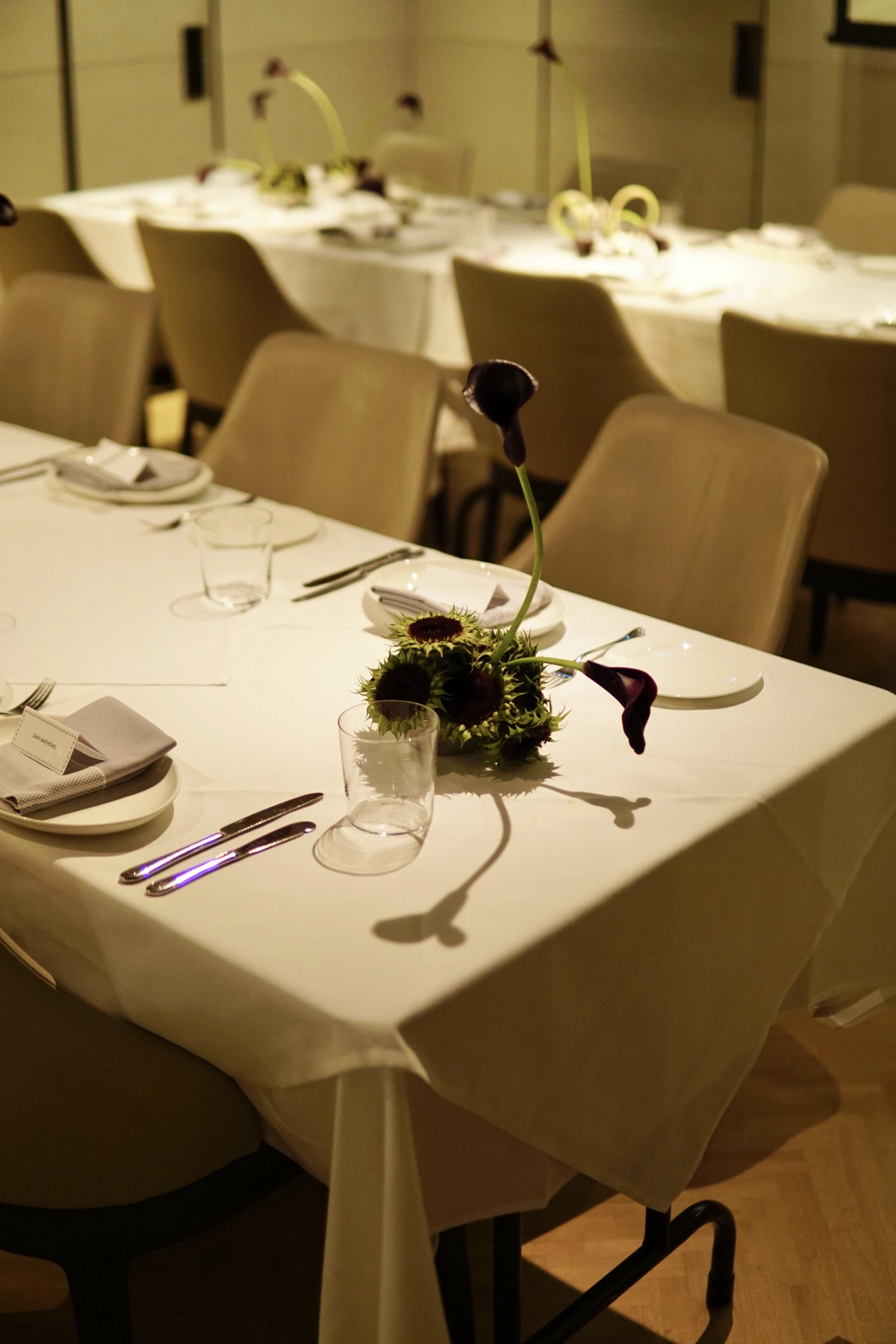 Green sunflower head centrepiece with two dark calla lilies