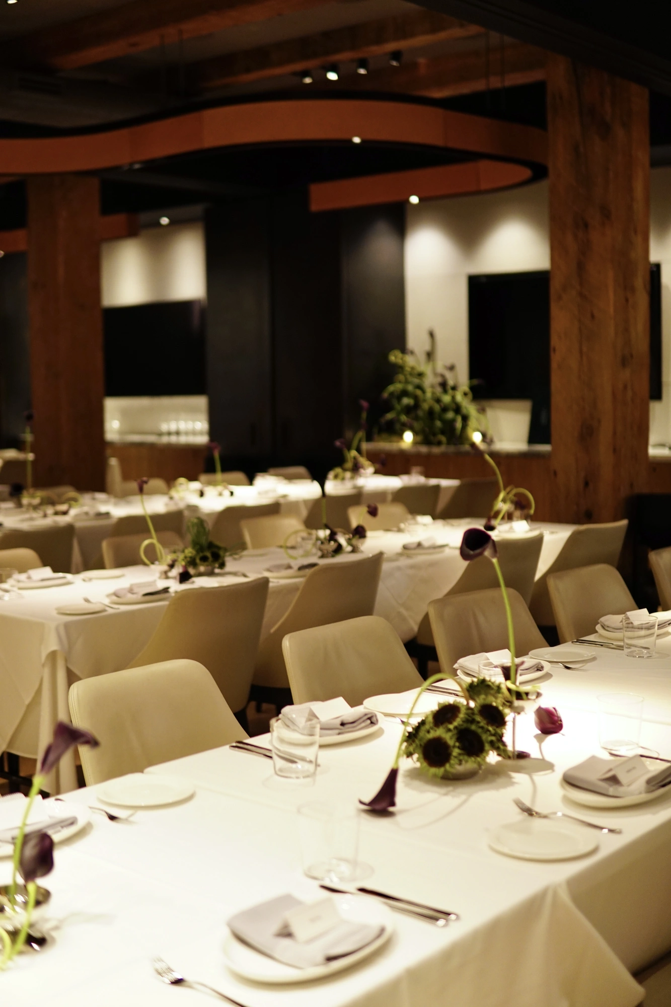 Wedding reception room with calla and sunflower centrepieces on long white tables