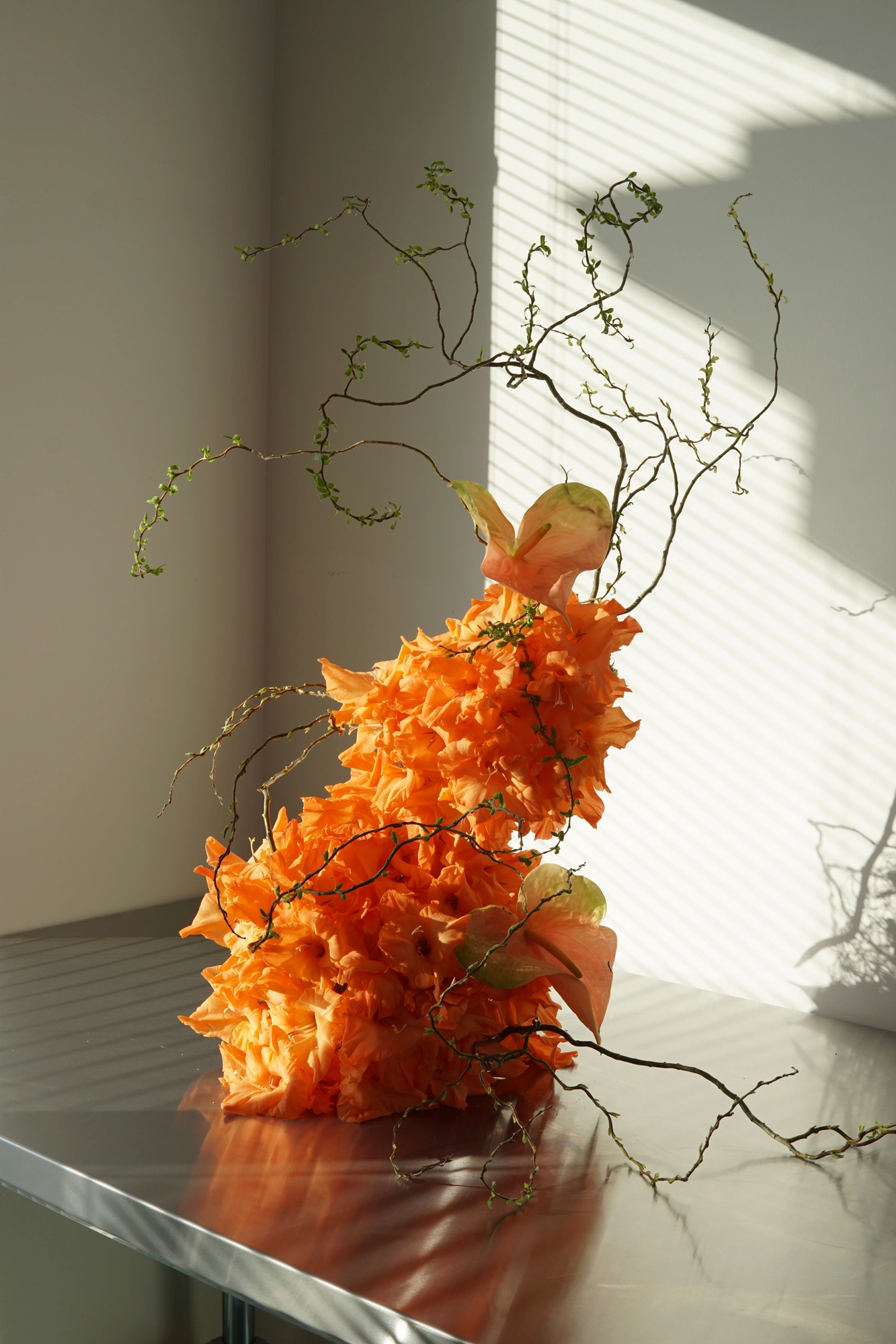 Orange and green arrangement in blue vessel